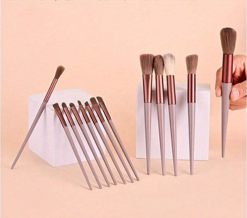 Set of makeup brushes with rose gold and silver handles on a pink background